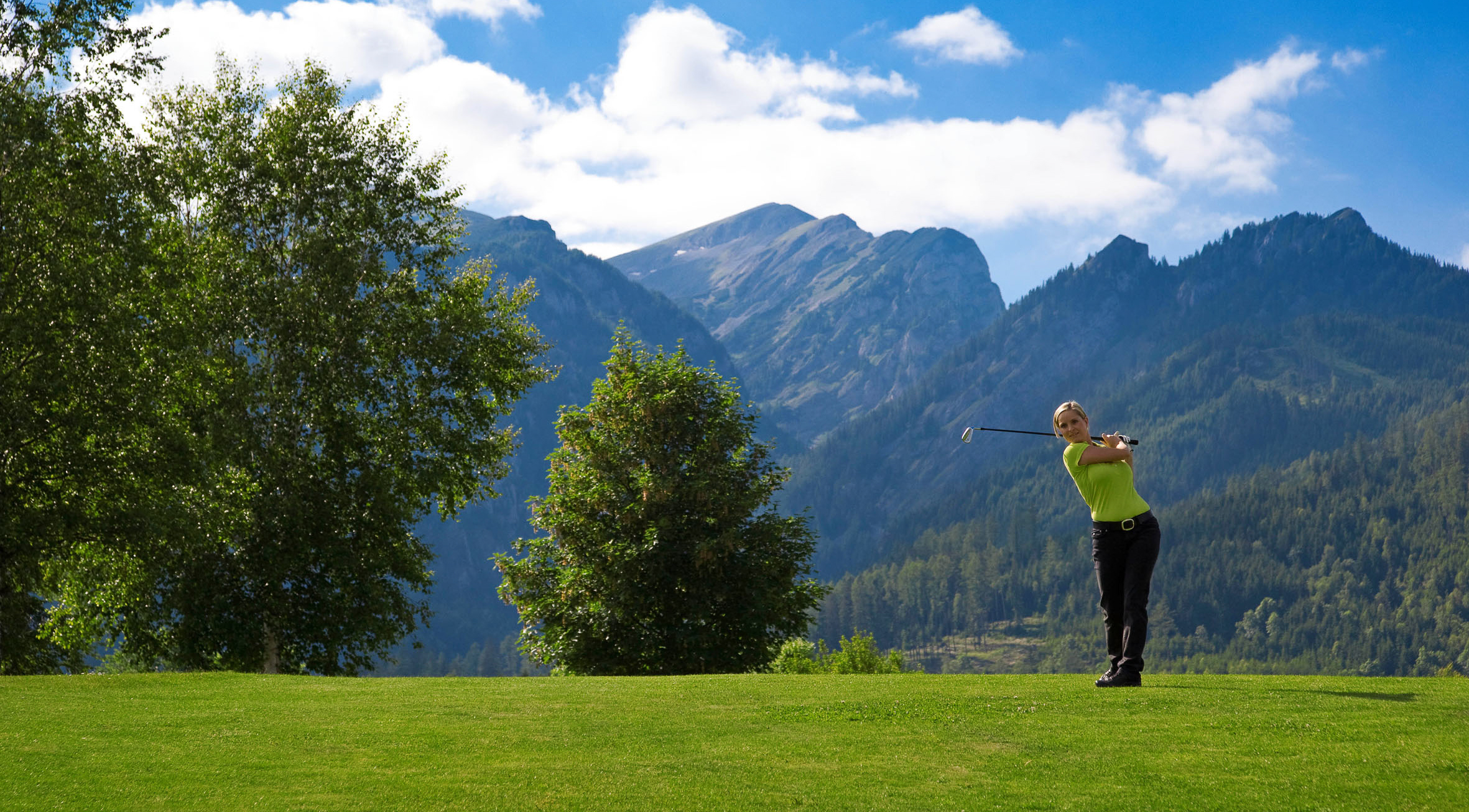 Golferin am Golfplatz Trofaiach vor der Kulisse des Reitingmassivs in ERZBERG LEOBEN
